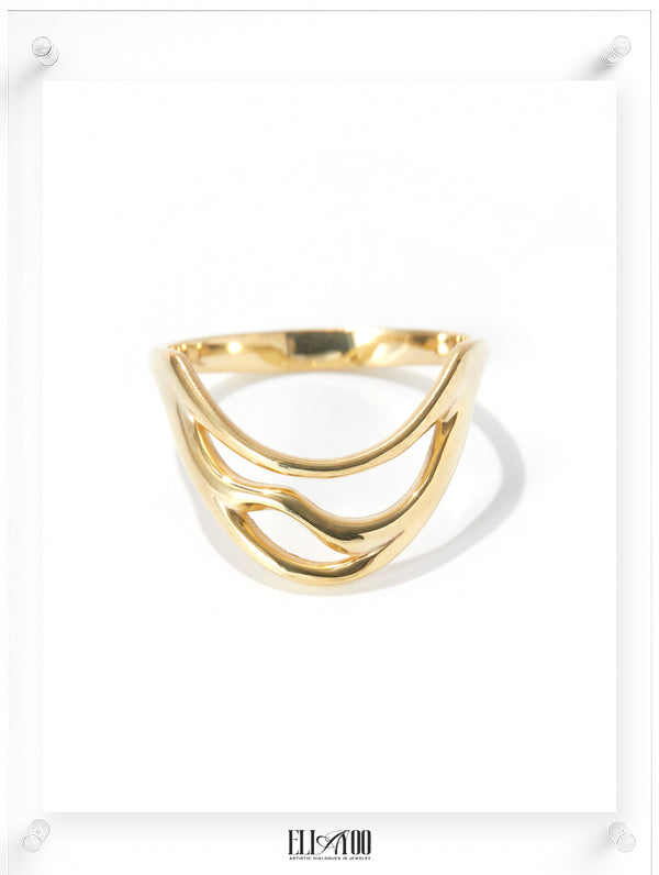 Sculptural gold ring with flowing wave-inspired lines, contemporary fine jewelry in polished yellow gold