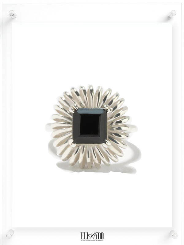 Princess cut onyx ring with sculptural silver petal setting, contemporary art-inspired design
