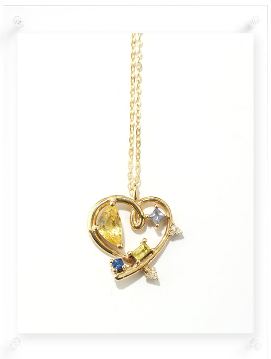 Gold necklace with a heart-shaped pendant on a white background