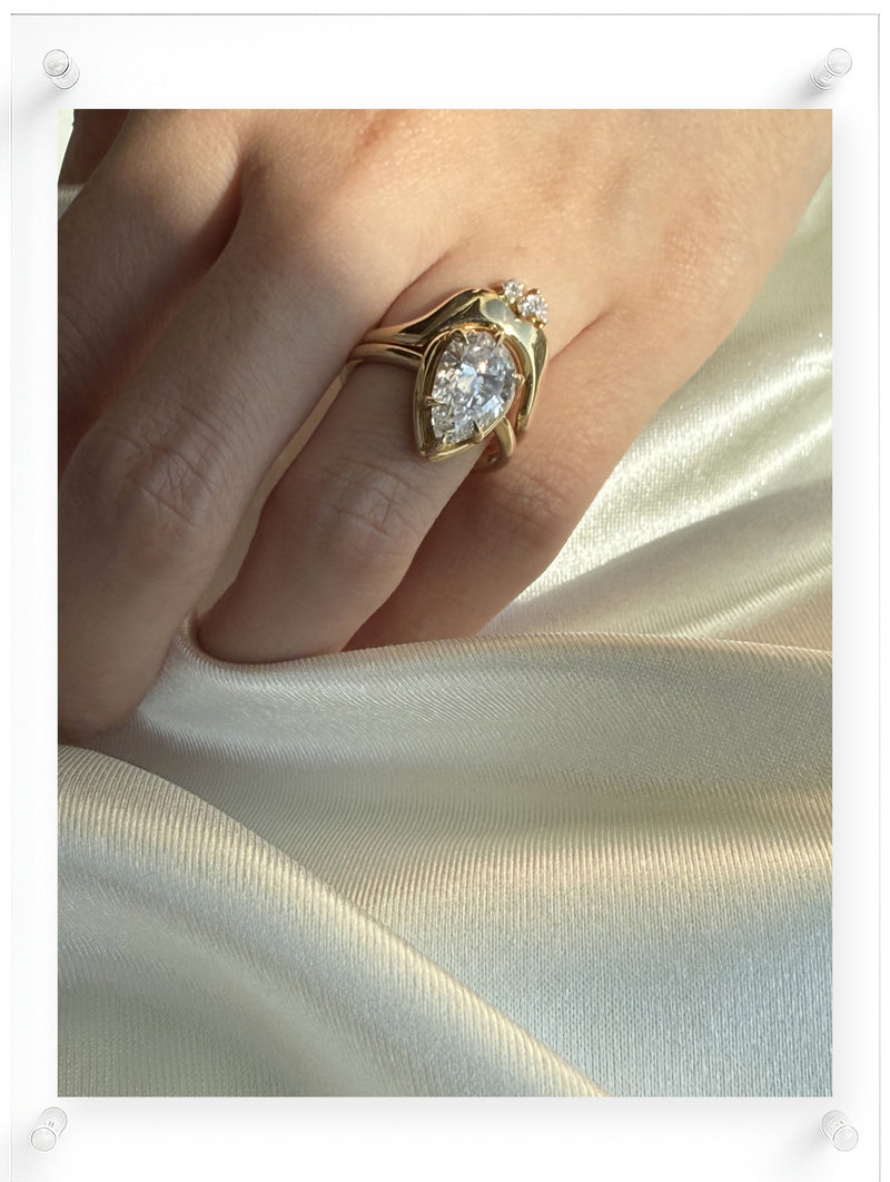 Model wearing Pear cut diamond yellow gold ring with guard ring