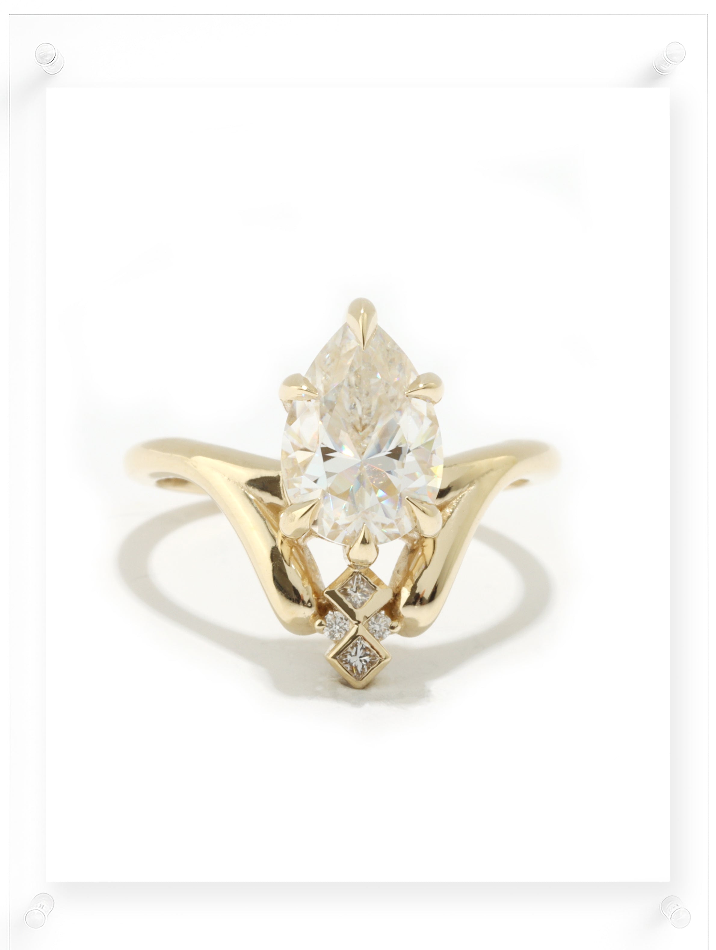 Gold ring with a large diamond and smaller diamonds on a white background