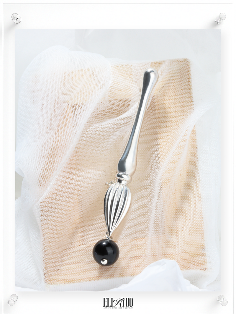 Front view of Silver brooch featuring a paint brush shape with a Onyx Sphere