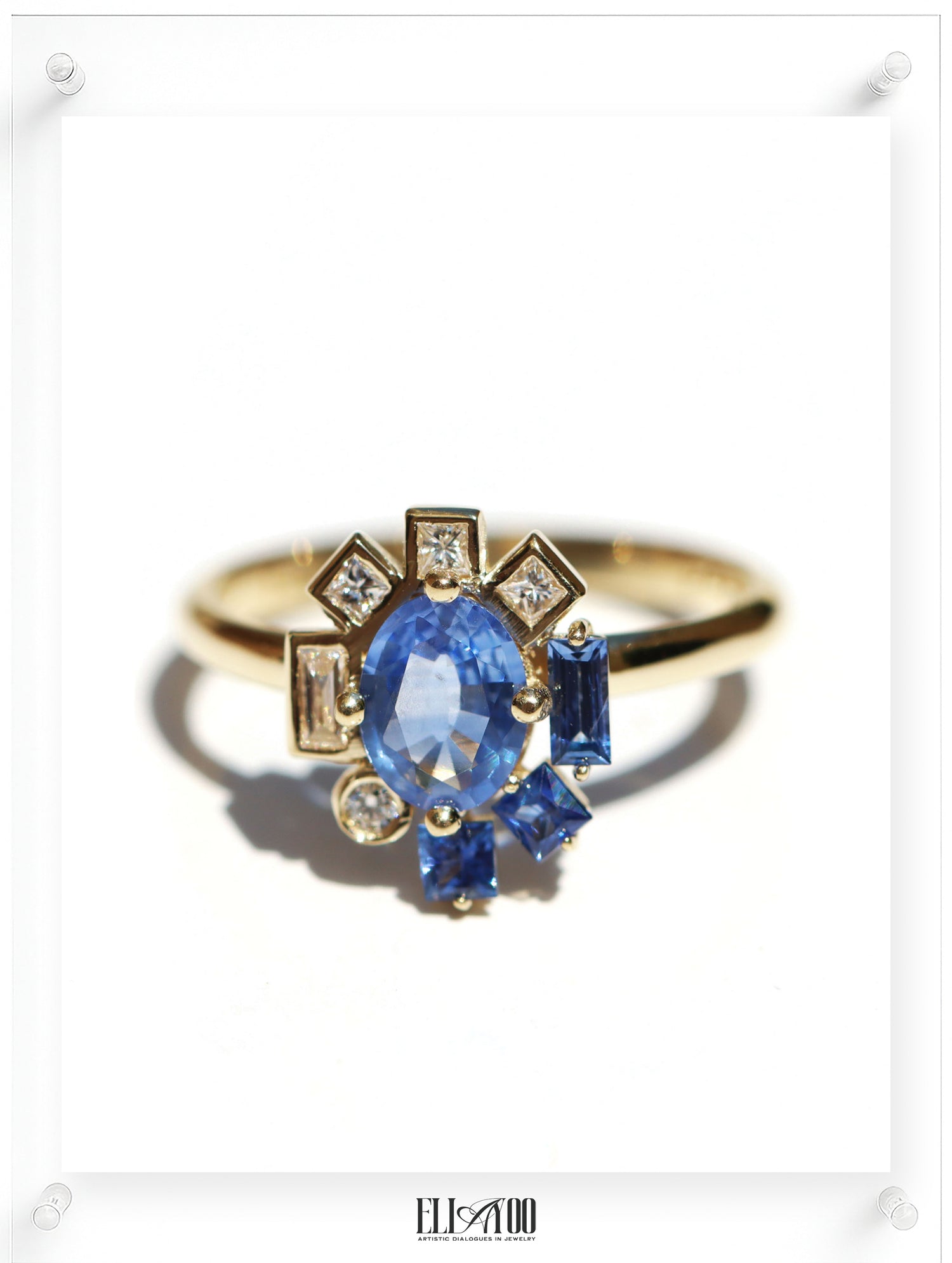 Gold ring with a blue gemstone on a white background