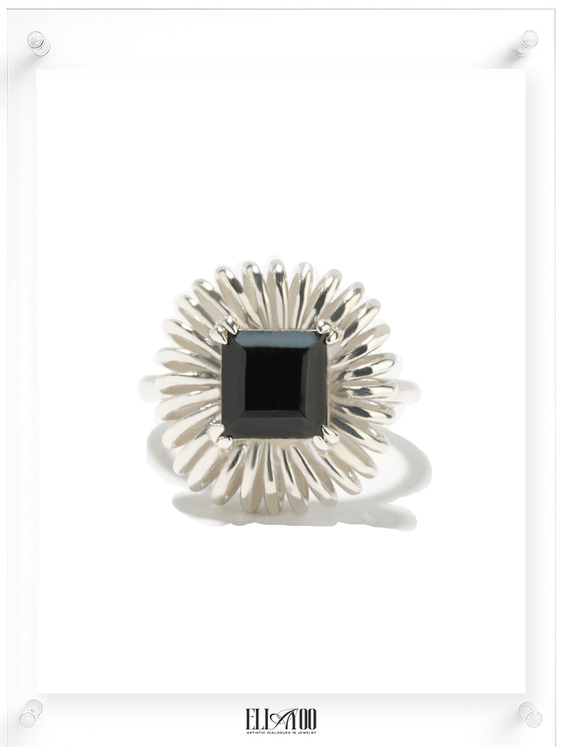Princess cut onyx ring with sculptural silver petal setting, contemporary art-inspired design