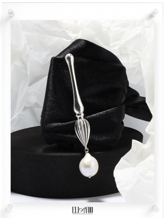 Front view of Silver brooch featuring a paint brush shape with a pearl