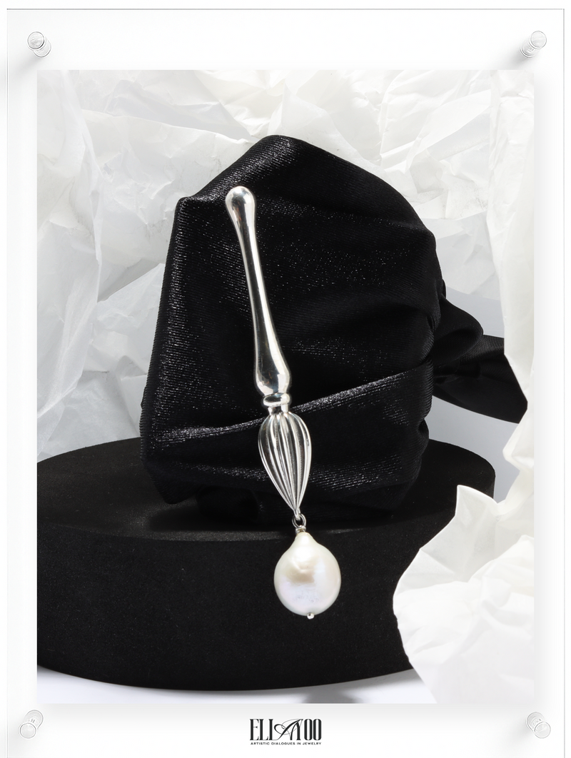 Front view of Silver brooch featuring a paint brush shape with a pearl