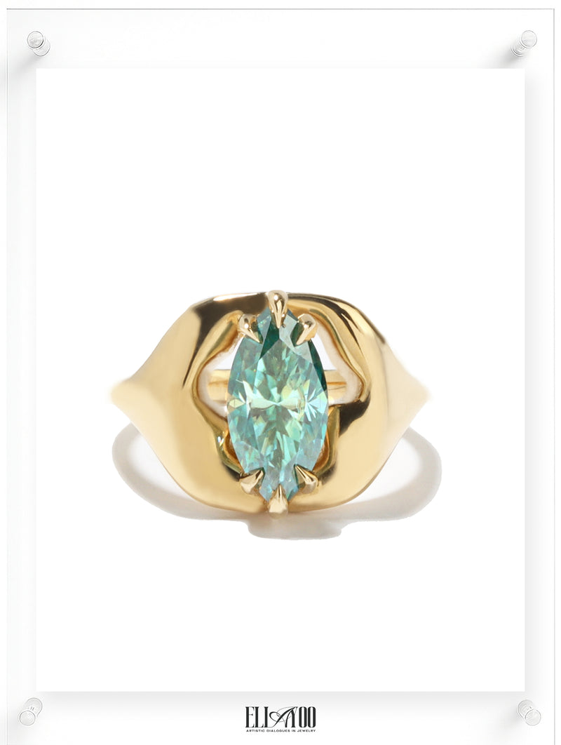 14k yellow Gold ring with a teal moissanite on a white background