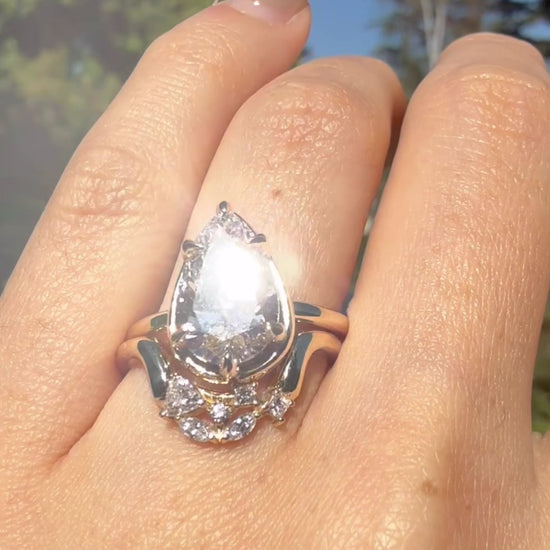 Video showing a 14K yellow gold ring with a pear shaped diamond center and diamond accent stones worn on hand.
