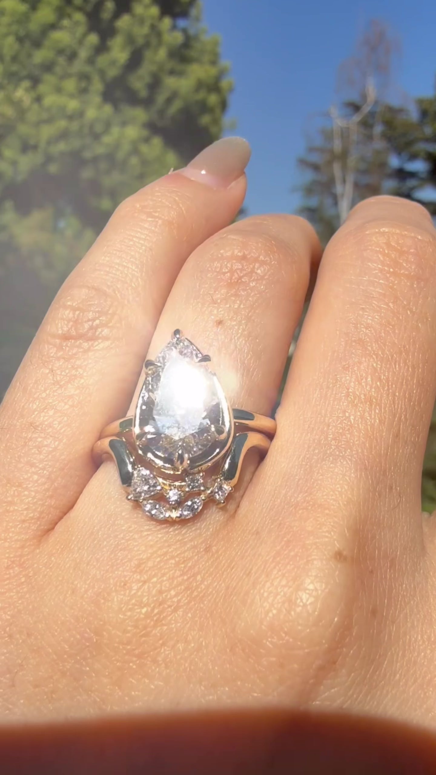 Video showing a 14K yellow gold ring with a pear shaped diamond center and diamond accent stones worn on hand.