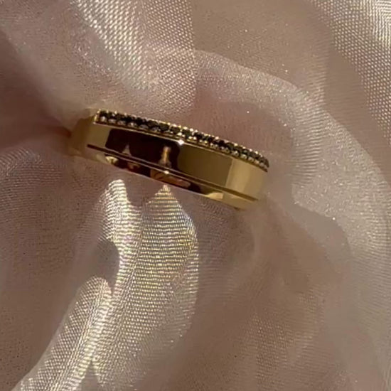 14K yellow gold band ring with black diamond pavé, close-up detail on sheer fabric, contemporary fine jewelry by Ella Yoo